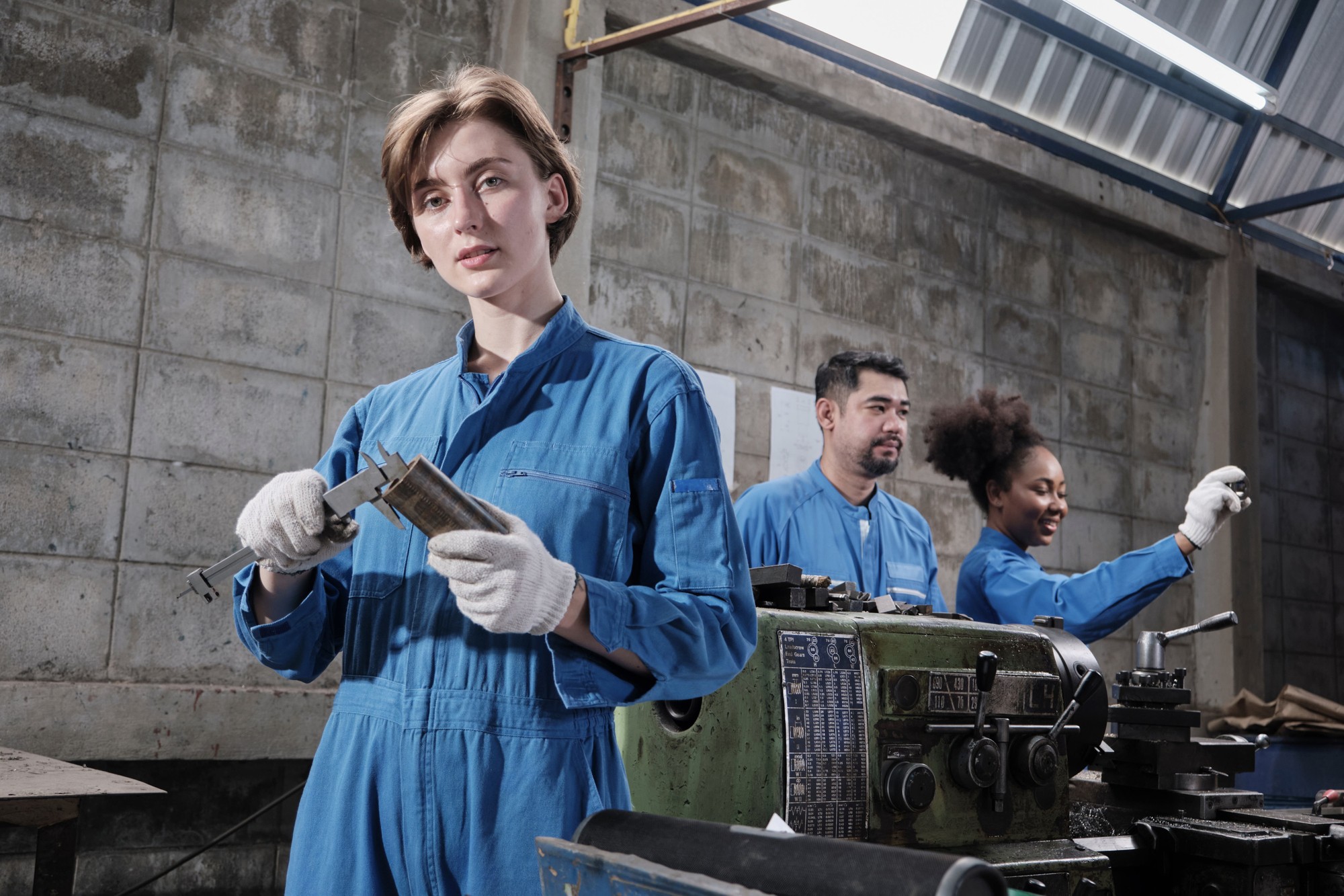 Drei Metallarbeiter an einer Werkbank